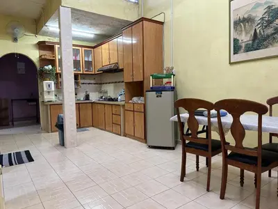 a kitchen with a table and chairs and a refrigerator at HOMESTAY Sg Petani in Sungai Petani