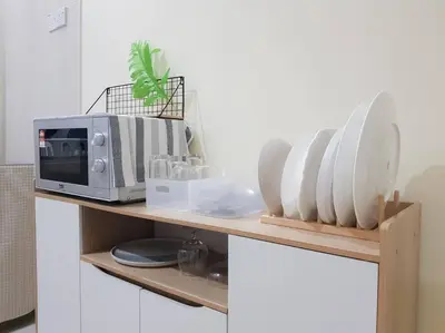 a shelf with a microwave and plates on it at Lovely Homestay in Gerik with Free Netflix & WiFi in Gerik