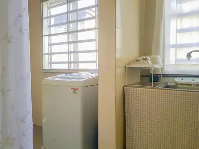 a small kitchen with a small refrigerator and a window at Lovely Homestay in Gerik with Free Netflix & WiFi in Gerik