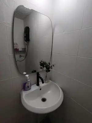a bathroom with a sink and a mirror at Georgetown Cozy 7 Bedrooms 13 Pax in George Town