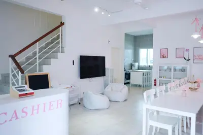 a white room with a staircase and a table with a laptop at Comfy Cafe 43 Homestay- Holiday Home in Tanah Rata