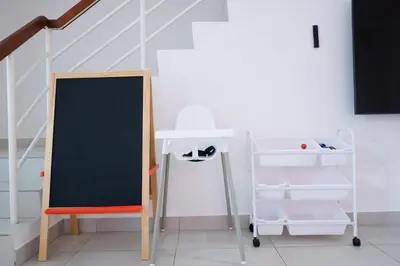 a chalkboard next to a desk and a chair with a shelf at Comfy Cafe 43 Homestay- Holiday Home in Tanah Rata