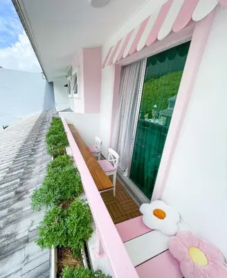 a balcony with a pink and white house at Comfy Cafe 43 Homestay- Holiday Home in Tanah Rata