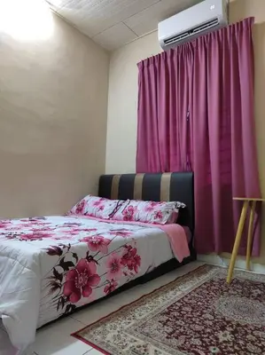 a bedroom with a bed with pink curtains and a window at Homestay Amin 4 Fully Aircond Bedroom & 2 Bathroom in Kulim