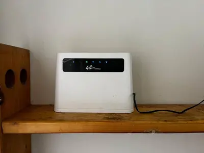 a white microwave sitting on top of a wooden shelf at Homestay Aishah in Seri Iskandar