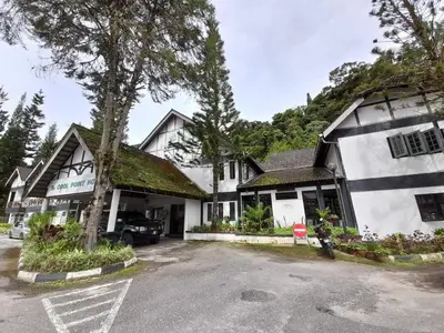 a building with a car parked in a parking lot at Hillside cottage tulip room with loteng in Tanah Rata