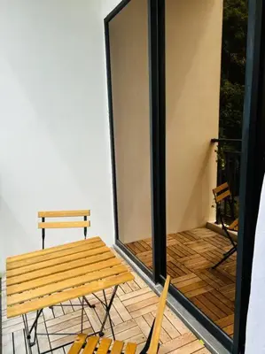 a balcony with a wooden bench and two chairs at The Cove Hillside Ipoh by Iconique in Tambun