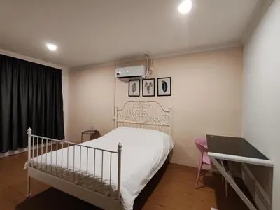 a bedroom with a white bed and a desk at Songtam Hotel in Ipoh