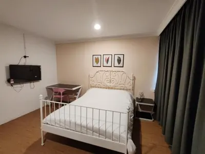 a bedroom with a white bed and a television at Songtam Hotel in Ipoh