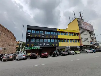 a large building with cars parked in a parking lot at Songtam Hotel in Ipoh