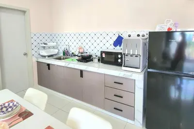 a kitchen with a sink and a refrigerator and a table at IPOH City Horizon08 - 8 mins to Concubine Lane and Old Town Ipoh, 3 mins Walking to Food Places & Convenient Store by Happy Homestay in Ipoh