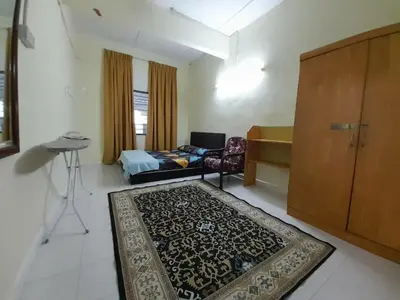 a room with a bed and a couch and a rug at Mukhriz 2 Homestay in Kulim