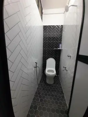 a bathroom with a toilet and a tiled floor at Mukhriz 2 Homestay in Kulim