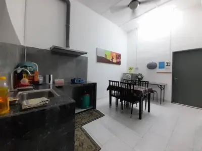 a kitchen with a sink and a table with chairs at Mukhriz 2 Homestay in Kulim