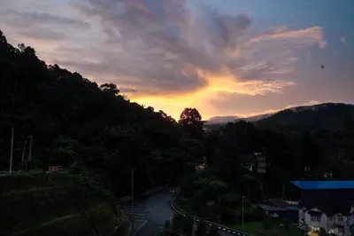 a view of a river with a sunset in the background at Cozy Homestay at Tanah Rata - Moonshot Highlanders in Tanah Rata