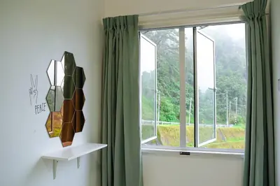 a window with green curtains in a room at Cozy Homestay at Tanah Rata - Moonshot Highlanders in Tanah Rata