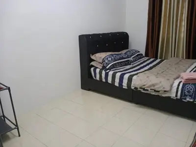 a bed with a black frame in a room at Suriati&Fhaiz Homestay in Sungai Petani