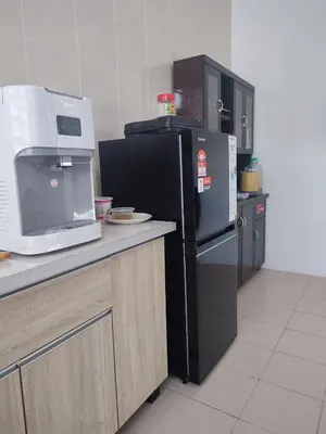 a kitchen with a black refrigerator and a microwave at Suriati&Fhaiz Homestay in Sungai Petani