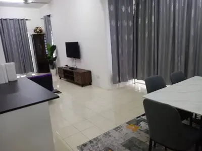 a living room with a table and chairs and a television at Suriati&Fhaiz Homestay in Sungai Petani