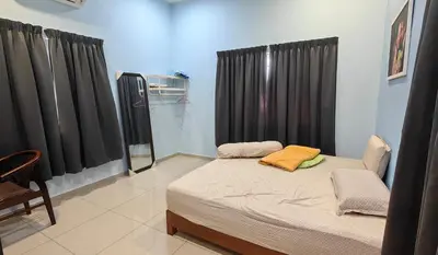 a bedroom with a bed with black curtains and a chair at Seaside cottage room stays in Sungai Besar