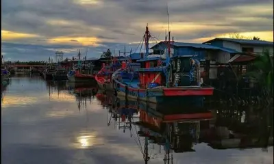 a group of boats are docked in the water at Seaside cottage room stays in Sungai Besar