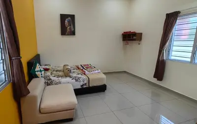 a room with a bed and a chair in it at Seaside cottage room stays in Sungai Besar