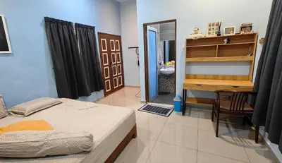 a bedroom with a bed and a desk and a mirror at Seaside cottage room stays in Sungai Besar