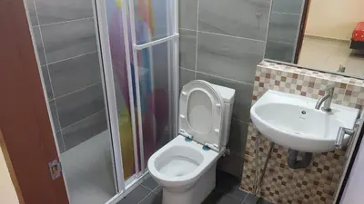a bathroom with a toilet and a sink at Seaside cottage room stays in Sungai Besar