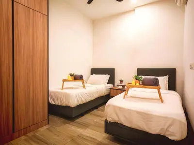 two beds in a small room with two tables at Ipoh Octagon Premium 7 Pax Condo One Free Parking by City Home Empire in Ipoh