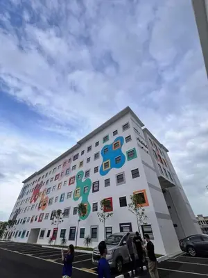 a large white building with colorful signs on it at Soho LESTARI in Seri Iskandar