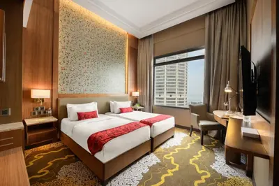 a hotel room with a bed and a desk and a window at St Giles Wembley Penang in George Town