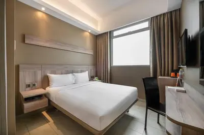 a bedroom with a bed and a desk and a window at Cititel Express Penang in George Town