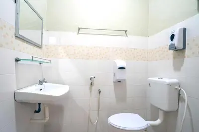 a bathroom with a toilet and a sink at De Clinique Hotel in Pangkor