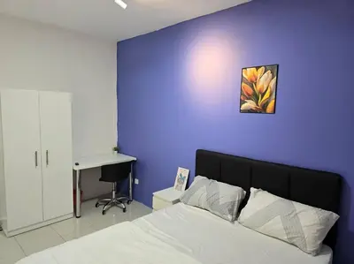 a bedroom with a purple wall with a bed and a desk at Stay at Anderson Condo 161 Ipoh Town FREEWIFITVBOX in Ipoh