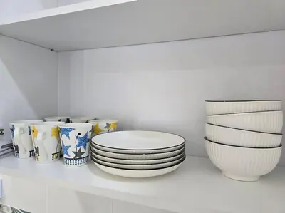 a group of plates and bowls sitting on a shelf at Stay at Anderson Condo 161 Ipoh Town FREEWIFITVBOX in Ipoh