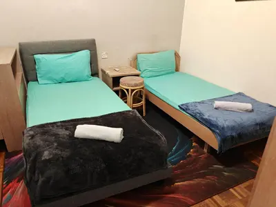 two beds in a room with towels on the floor at Bayu Emas Batu Ferringhi Penang in Batu Ferringhi