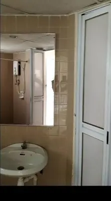 a bathroom with a sink and a mirror at Bayu Emas Batu Ferringhi Penang in Batu Ferringhi