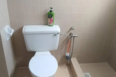 a bathroom with a toilet with a bottle on top of it at Bayu Emas Batu Ferringhi Penang in Batu Ferringhi