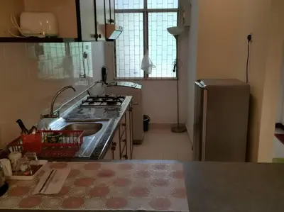 a kitchen with a stove and a sink and a refrigerator at Bayu Emas Batu Ferringhi Penang in Batu Ferringhi