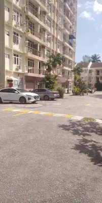 two cars parked in a parking lot in front of a building at Bayu Emas Batu Ferringhi Penang in Batu Ferringhi