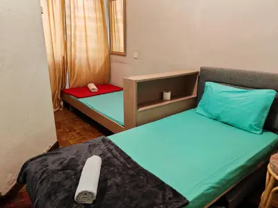 a small room with a bed and a chair at Bayu Emas Batu Ferringhi Penang in Batu Ferringhi