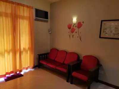 a living room with two red chairs and a window at Bayu Emas Batu Ferringhi Penang in Batu Ferringhi