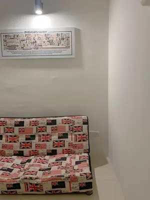 a bed in a white room with a wall at Zara Cozy Homestay in Seri Iskandar