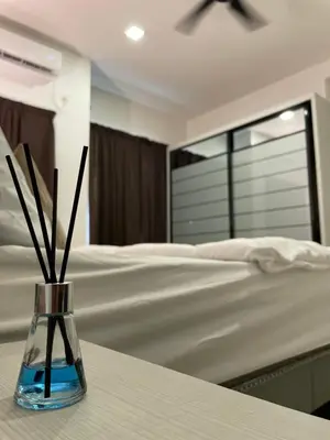 a vase with sticks in it next to a bed at Zara Cozy Homestay in Seri Iskandar