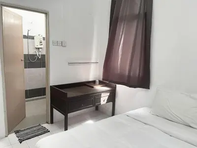 a bedroom with a bed and a table with a mirror at Grand Star Hotel in Batu Ferringhi