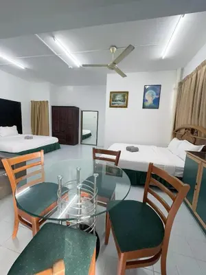 a room with a table and chairs and a bed at Grand Star Hotel in Batu Ferringhi