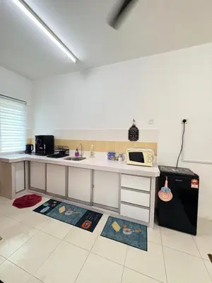 a kitchen with a counter with a microwave and a refrigerator at Home-Away Homestay in Gerik
