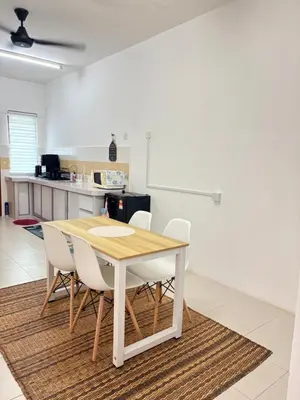 a kitchen and dining room with a table and chairs at Home-Away Homestay in Gerik
