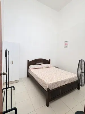 a bedroom with a bed in a white room at Home-Away Homestay in Gerik