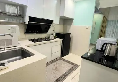 a white kitchen with a sink and a stove at Homestay Pulau Pinang Urban Sky Guesthouse in Bayan Lepas